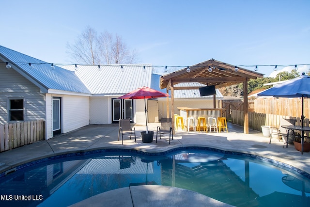 view of swimming pool featuring an outdoor bar and a patio