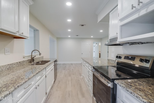 kitchen featuring sink, light stone counters, light hardwood / wood-style flooring, white cabinets, and appliances with stainless steel finishes