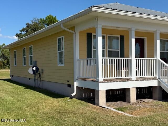 view of side of home featuring a porch and a yard