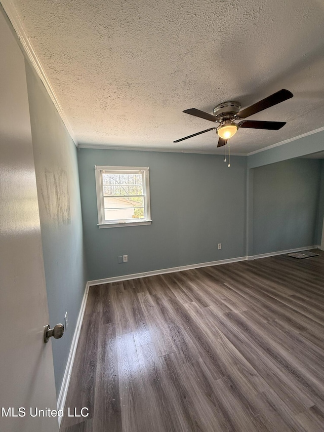 spare room featuring crown molding, baseboards, wood finished floors, a textured ceiling, and a ceiling fan