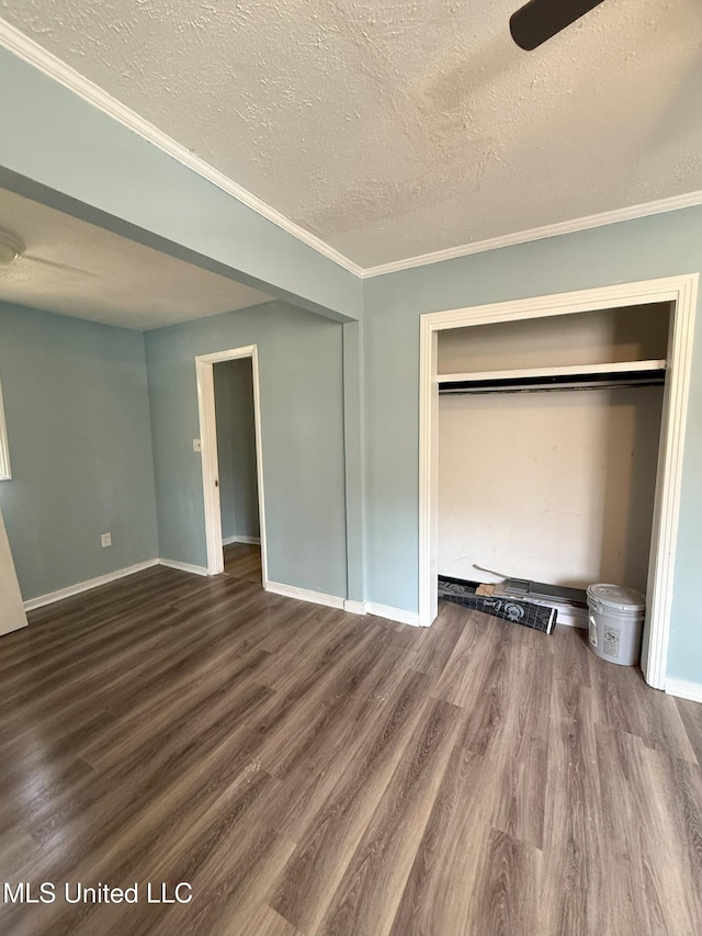 unfurnished bedroom featuring a closet, baseboards, a textured ceiling, and wood finished floors