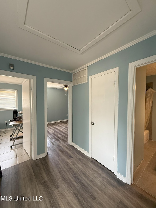 corridor with baseboards, attic access, wood finished floors, and ornamental molding