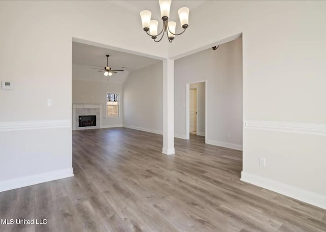 3752 Roland Dr, Southaven, MS 38672 - unfurnished living room with a chandelier, a ceiling fan, baseboards, wood finished floors, and vaulted ceiling