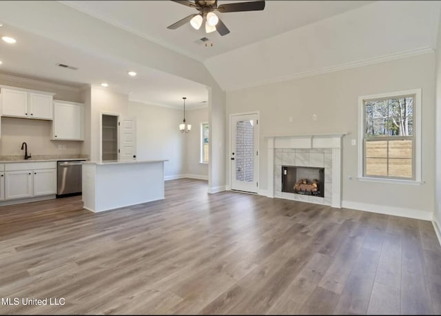 3752 Roland Dr, Southaven, MS 38672 - unfurnished living room featuring a ceiling fan, crown molding, a tile fireplace, baseboards, and a chandelier