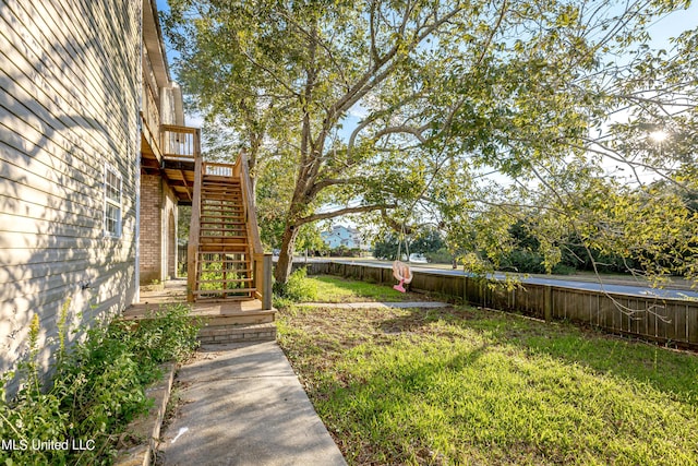 view of yard with stairs, a wooden deck, and a fenced backyard