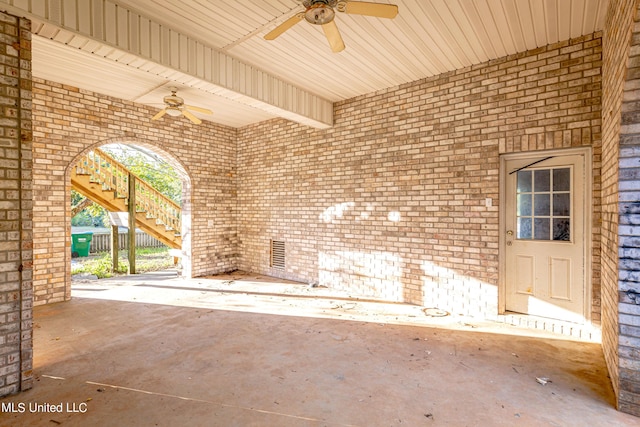 view of patio featuring ceiling fan and stairs