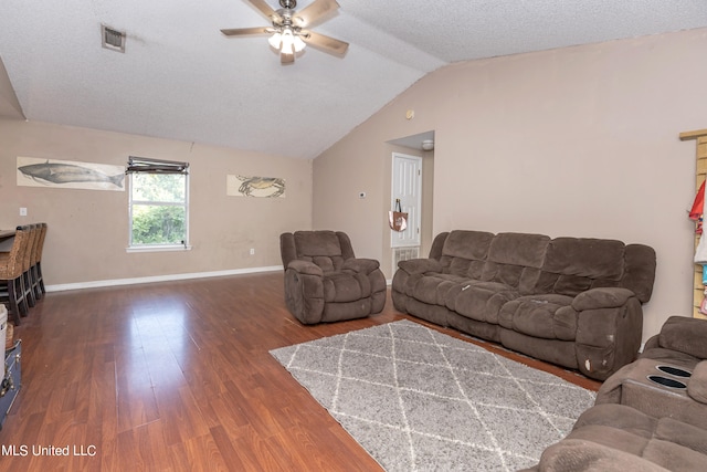 living room featuring dark wood-type flooring, vaulted ceiling, a textured ceiling, and ceiling fan