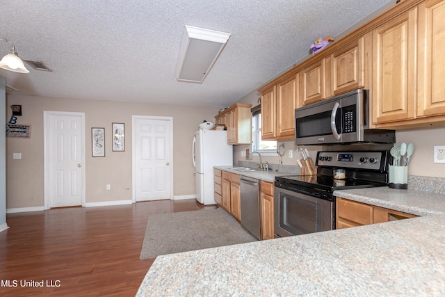 kitchen with sink, stainless steel appliances, a textured ceiling, and dark hardwood / wood-style flooring