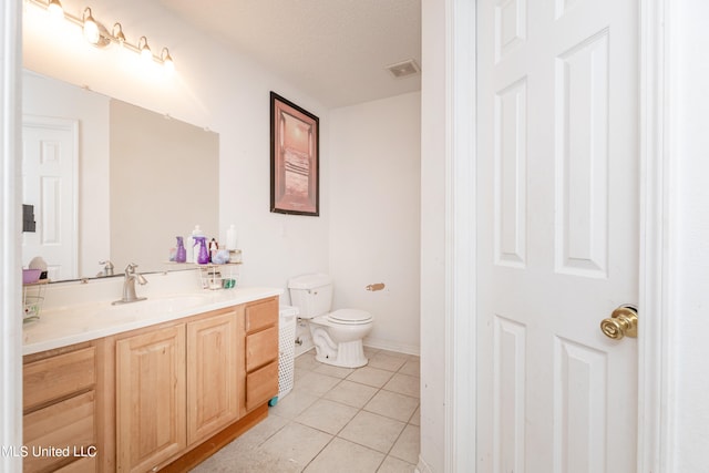 bathroom with vanity, a textured ceiling, toilet, and tile patterned floors