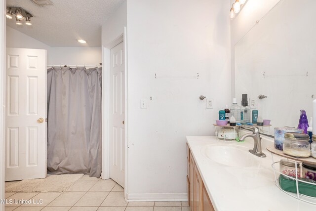 bathroom featuring vanity, a textured ceiling, and tile patterned flooring