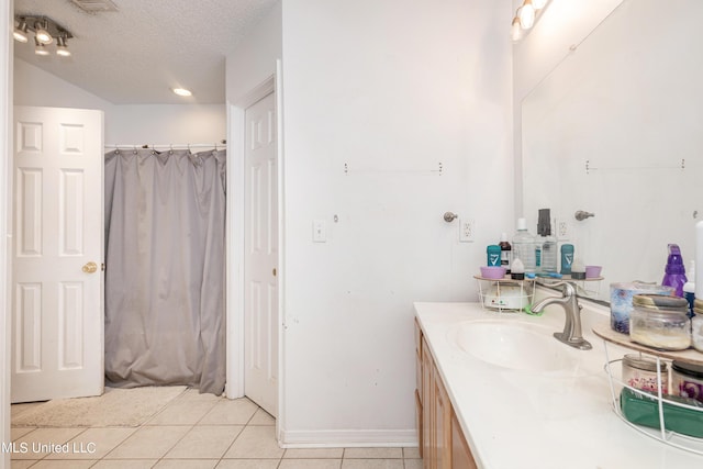 bathroom featuring a shower with shower curtain, tile patterned flooring, vanity, and a textured ceiling