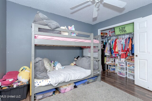 bedroom featuring a closet, ceiling fan, a textured ceiling, and dark hardwood / wood-style flooring