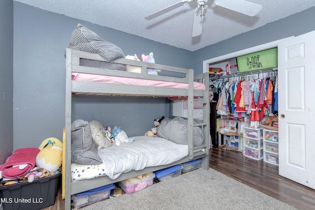 bedroom with wood finished floors, a ceiling fan, a textured ceiling, and a closet