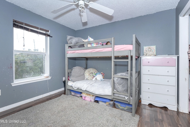 bedroom with dark hardwood / wood-style flooring, a textured ceiling, and ceiling fan