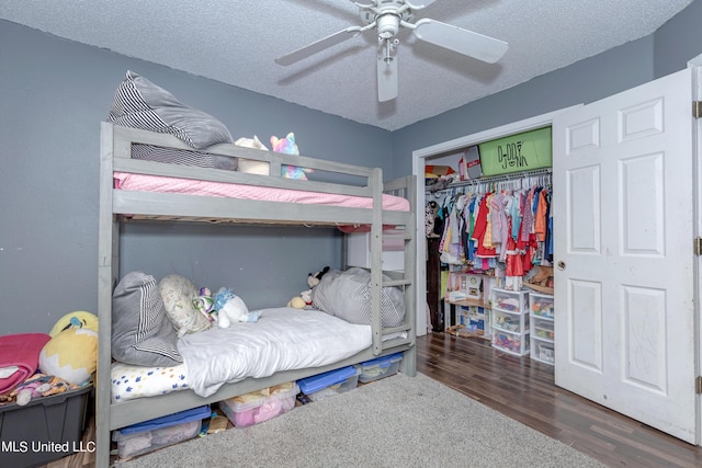 bedroom with wood finished floors, a ceiling fan, a textured ceiling, and a closet