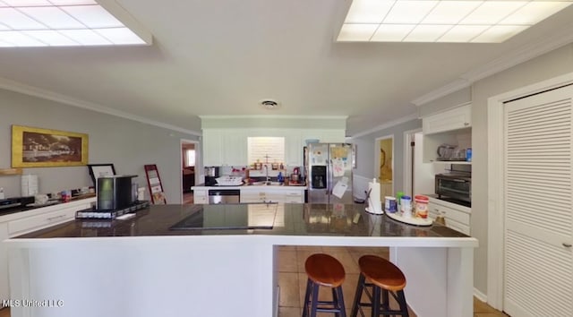 269 Weecama Dr, Ferriday, LA 71334 - kitchen featuring crown molding, dark countertops, stainless steel appliances, and white cabinetry