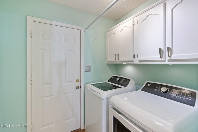 washroom with washer and clothes dryer, cabinets, and a textured ceiling