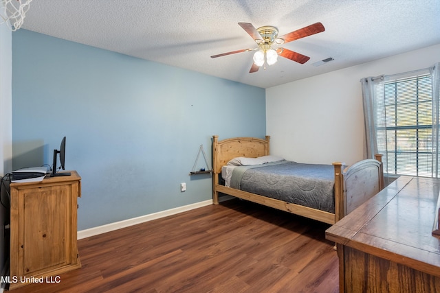 bedroom featuring ceiling fan, dark hardwood / wood-style flooring, and a textured ceiling