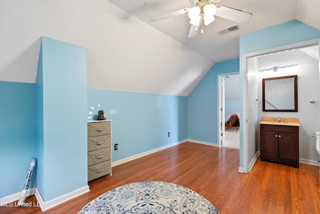 bonus room with ceiling fan, light hardwood / wood-style floors, a textured ceiling, and vaulted ceiling