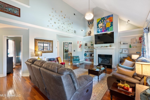 living room featuring built in features, high vaulted ceiling, ornamental molding, and hardwood / wood-style flooring