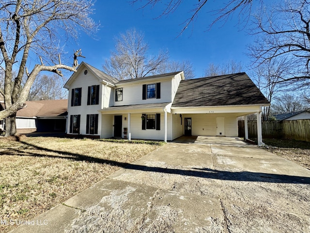 view of front of home featuring a front yard, concrete driveway, fence, and an attached carport