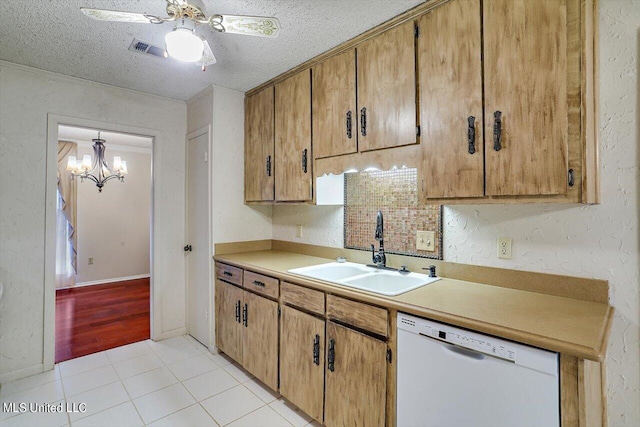 kitchen with light tile patterned floors, a textured ceiling, white dishwasher, ceiling fan with notable chandelier, and sink