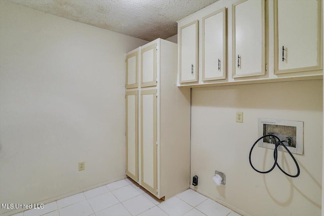 laundry area with hookup for a washing machine, a textured ceiling, and cabinets