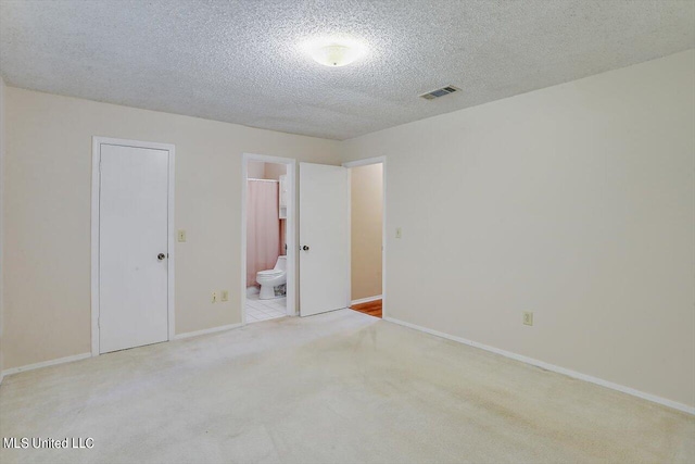 carpeted spare room featuring a textured ceiling