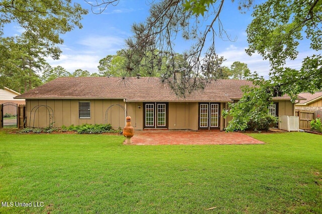 back of property with a patio, french doors, and a lawn