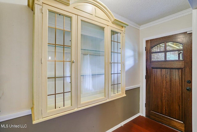 entrance foyer with crown molding, a textured ceiling, and dark hardwood / wood-style flooring