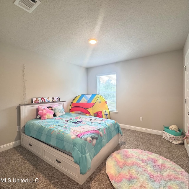 bedroom with a textured ceiling and dark colored carpet