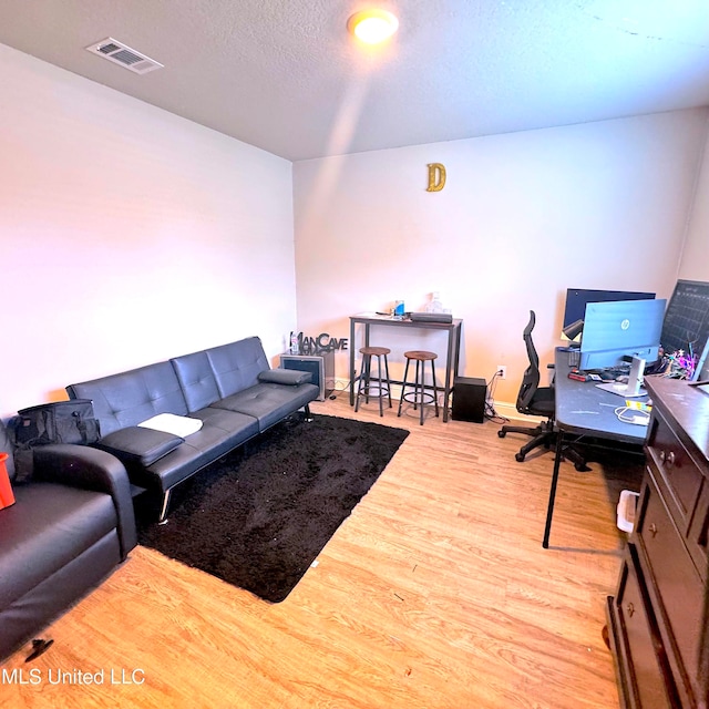 living room featuring a textured ceiling and light hardwood / wood-style floors