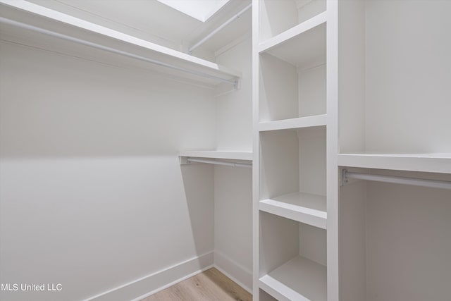 walk in closet with light hardwood / wood-style flooring