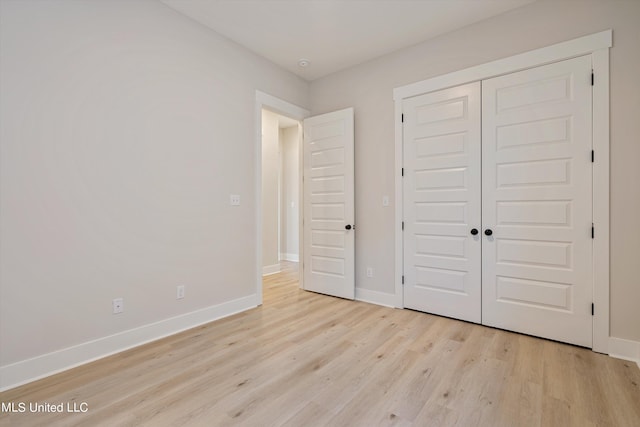 unfurnished bedroom with a closet and light hardwood / wood-style floors