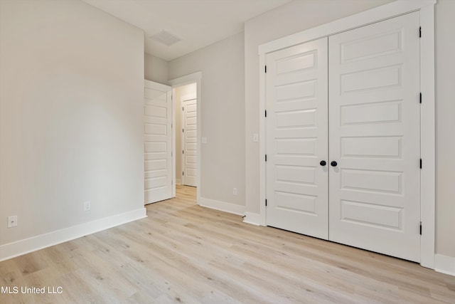 unfurnished bedroom with light hardwood / wood-style floors and a closet