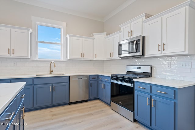 kitchen with blue cabinetry, light hardwood / wood-style flooring, stainless steel appliances, and backsplash