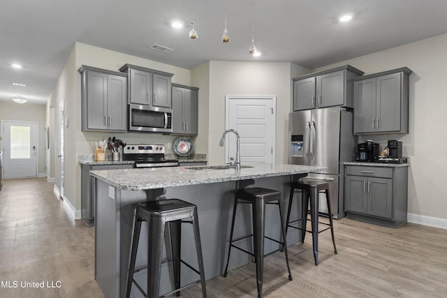 kitchen with a sink, appliances with stainless steel finishes, gray cabinets, and visible vents