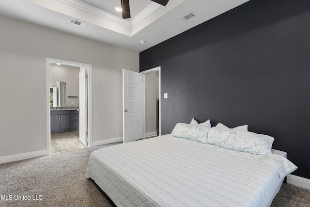 bedroom with crown molding, a raised ceiling, light carpet, and visible vents