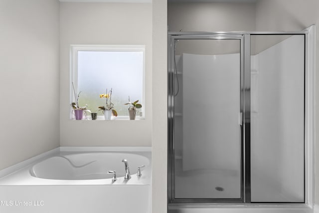 full bathroom with a shower stall and a bath