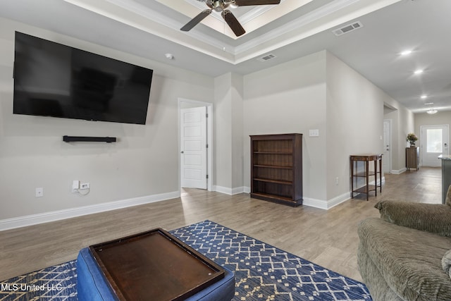 living area with visible vents, a ceiling fan, and wood finished floors