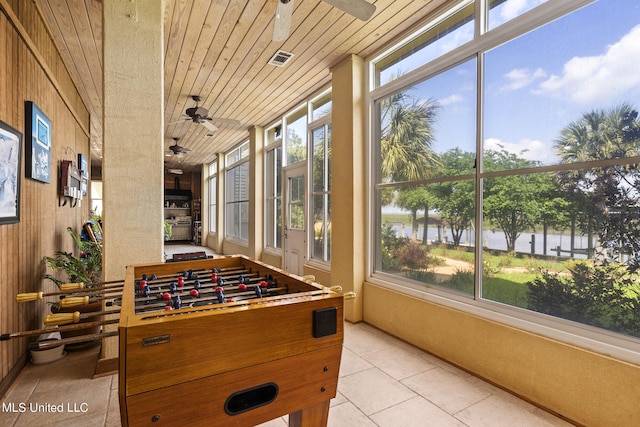 playroom featuring a water view, wooden ceiling, and a wealth of natural light