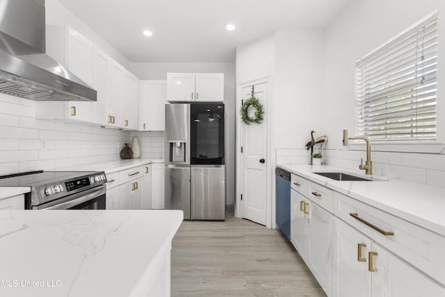 14789 Nassau Dr, Biloxi, MS 39532 - kitchen with appliances with stainless steel finishes, wall chimney exhaust hood, white cabinets, decorative backsplash, and recessed lighting