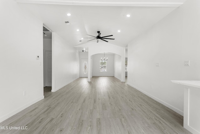 14789 Nassau Dr, Biloxi, MS 39532 - unfurnished living room featuring arched walkways, light wood finished floors, a ceiling fan, lofted ceiling, and a chandelier