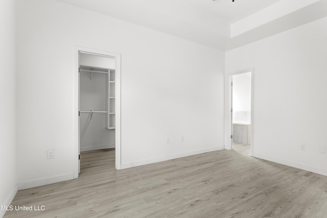 14789 Nassau Dr, Biloxi, MS 39532 - unfurnished bedroom featuring wood finished floors, a walk in closet, a closet, and ensuite bathroom