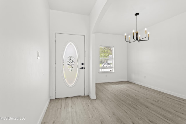 14789 Nassau Dr, Biloxi, MS 39532 - entrance foyer with a chandelier, light wood-style floors, and arched walkways