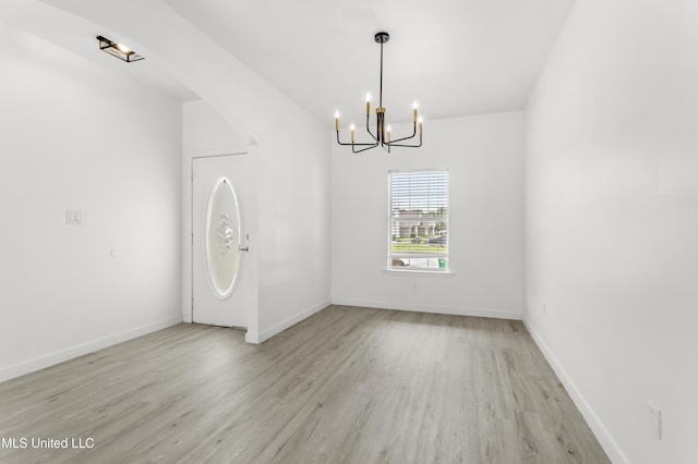 14789 Nassau Dr, Biloxi, MS 39532 - empty room with a chandelier, light wood-style floors, and vaulted ceiling