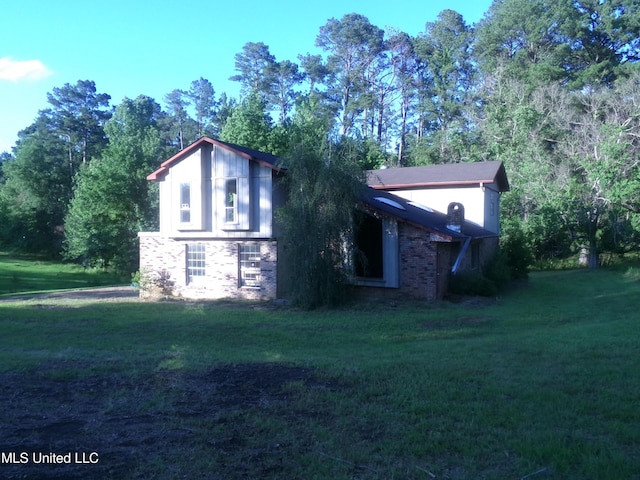 view of side of home featuring a yard and stone siding