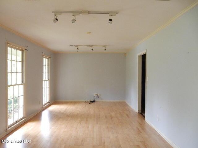 1510 Springridge Dr, Jackson, MS 39211 - unfurnished room featuring rail lighting, crown molding, healthy amount of natural light, light wood finished floors, and baseboards
