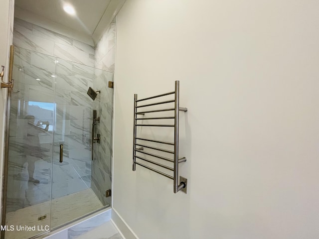 bathroom featuring a shower with door and radiator heating unit