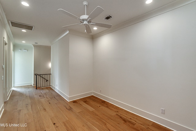 empty room featuring ornamental molding, ceiling fan, and light wood-type flooring